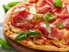 Pizza with dry cured ham and basil
